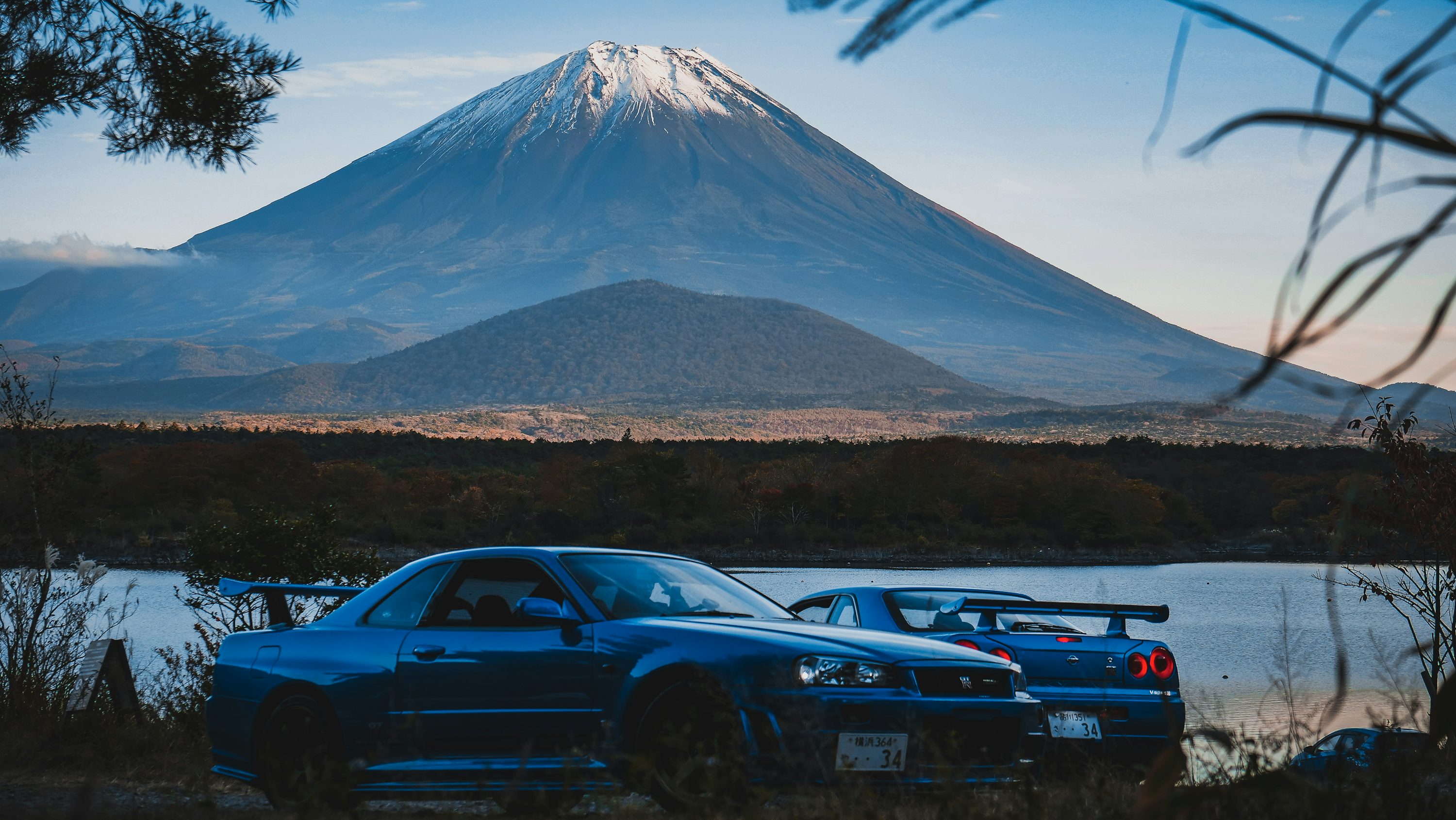 Background image of a scenic mountain road with a JDM car driving